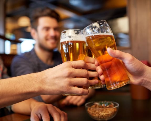 Group of Friends Toasting with Beers at a Bar