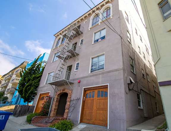 A building with a brown door and a fire escape.