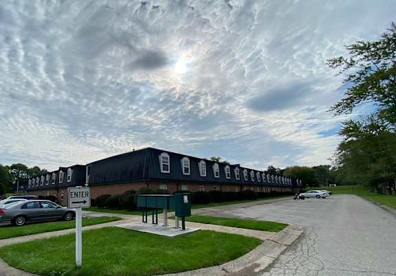 A parking lot with a building in the background and a sign that says