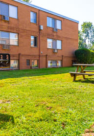 a picnic table in a yard in front of a brick building