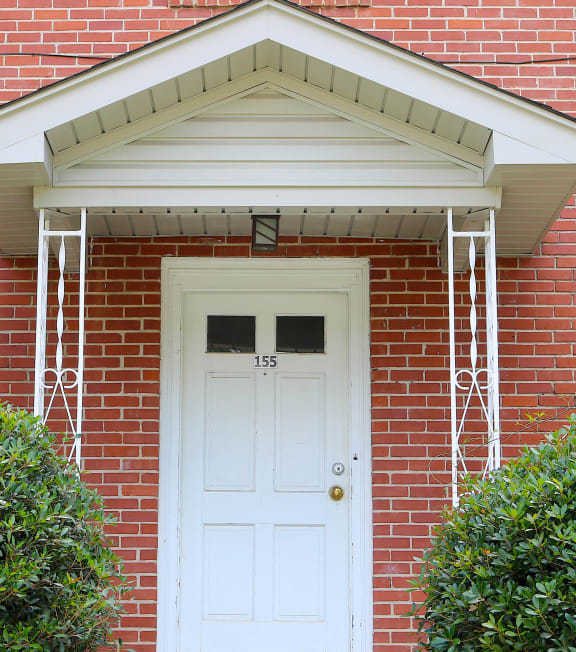 the front of a brick house with a white door