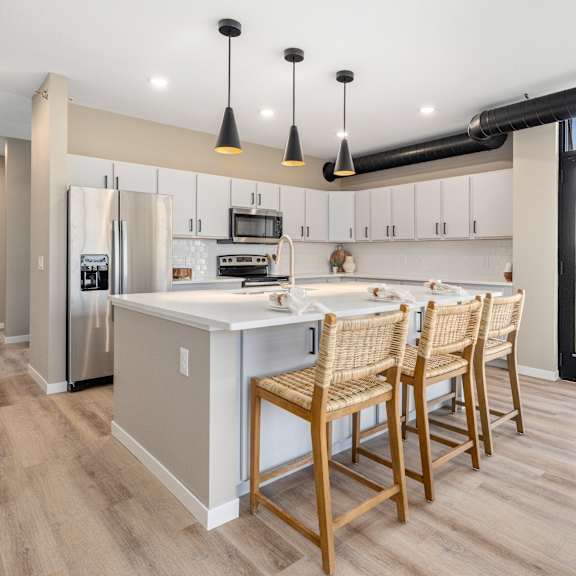 A modern kitchen with wooden floors and furniture.