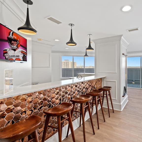 a bar with wooden stools in a room with a pool table