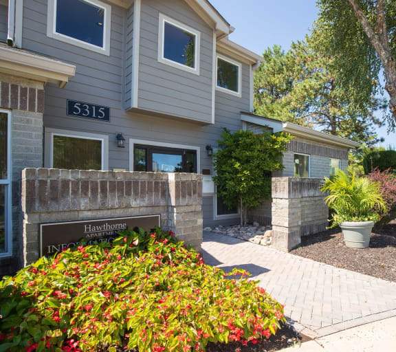 The exterior of the Hawthorne Apartments clubhouse, showcasing a welcoming entrance and surrounding greenery.