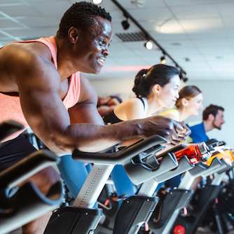 Several people riding on stationary bikes