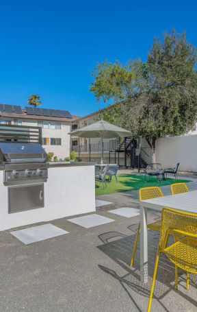 a patio with a table and chairs and a barbecue grill at The Hills Apartments at Thousand Oaks, California, 91360