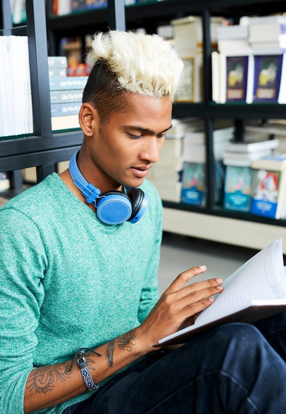 this is a photo of a young man reading at the local bookstore.  at The Biltmore, Dallas, Texas