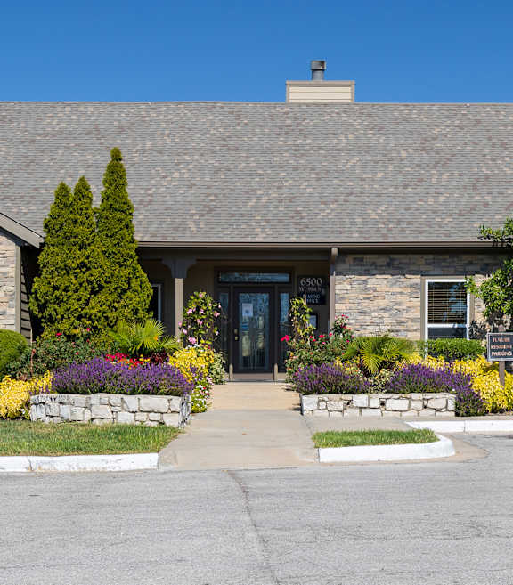 Outdoor swimming pool at Cedar Crest Apartments with lounge chairs and landscaped surroundings for residents to relax.