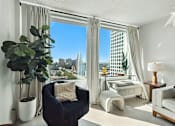 Thumbnail 34 of 40 - A living room with a view of the city through large windows.