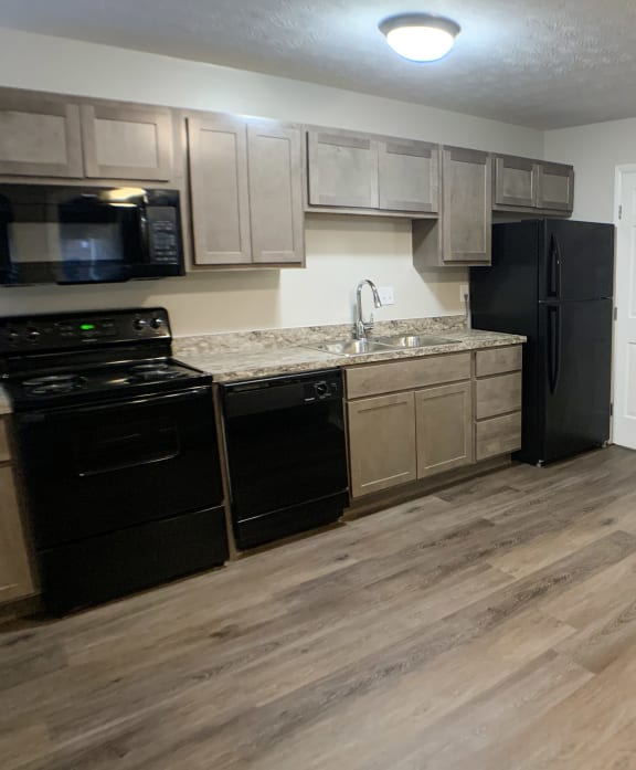 a kitchen with black appliances  at Revere Village Apartments, Centerville, OH, 45458and wooden floors