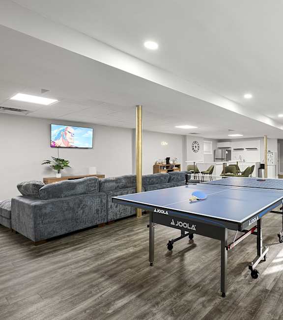 a games room with a ping pong table and a tv at Gardens at Washington Park in Atlanta, Georgia
