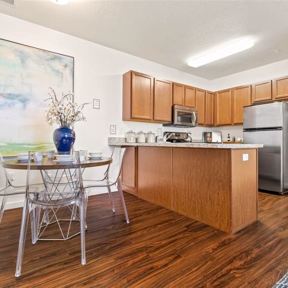 a kitchen with stainless steel appliances and a table with chairs