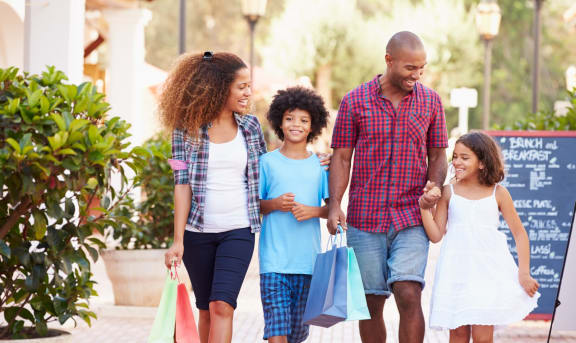 Young Family Smiling While out Shopping Together 