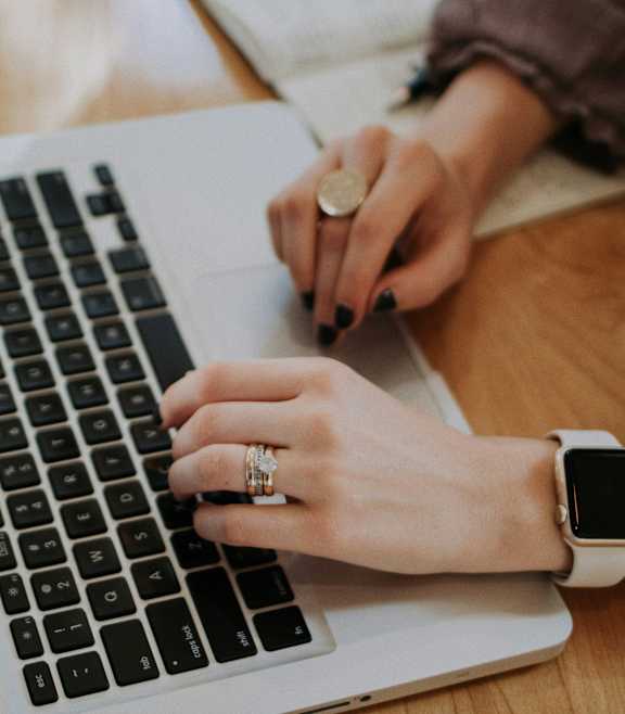 A person is typing on a laptop keyboard.
