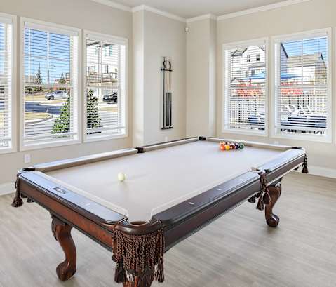A pool table in a room with a view of the city.