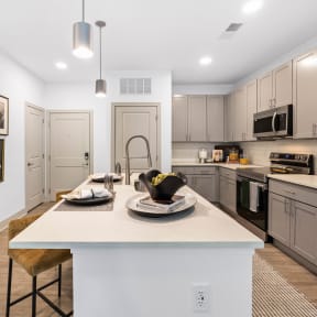 an open kitchen with a large island with a white counter top