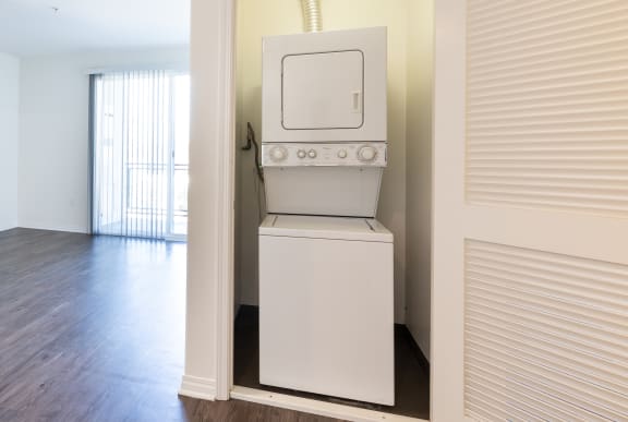 an empty living room with a white stove and a microwave in it