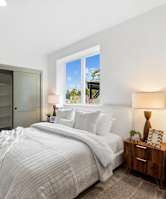 A bedroom with a large bed and a window.