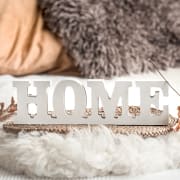 a home sign on a couch with christmas decorations
