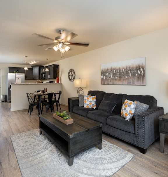 A living room with a grey couch and a wooden coffee table.