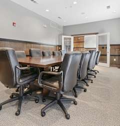 A conference room with a long table and chairs.
