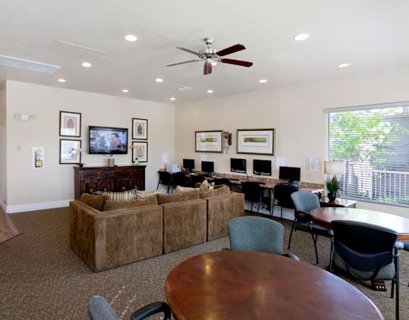 A living room with a brown couch and a ceiling fan.