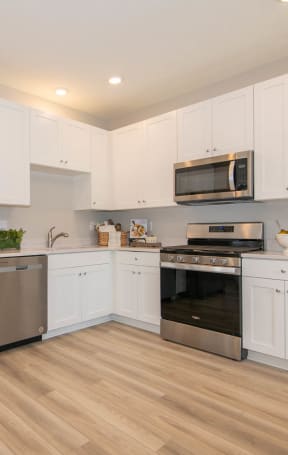 a kitchen with stainless steel appliances and white cabinets at Jackson Run Townhomes, Whitestown