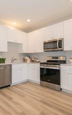 A kitchen with white cabinets and stainless steel appliances.