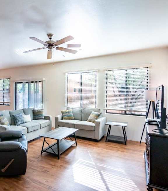 A living room with a black leather chair and a white couch.