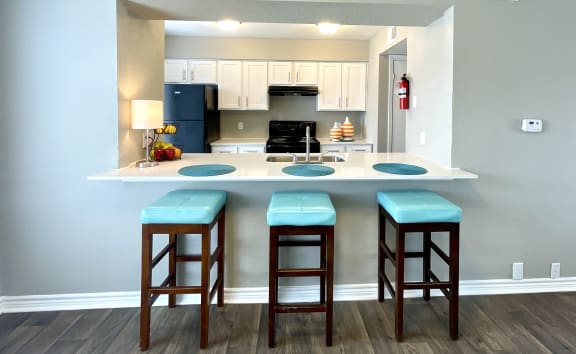 a kitchen with a breakfast bar and a stove top oven  at The Alara, Houston, TX, 77060