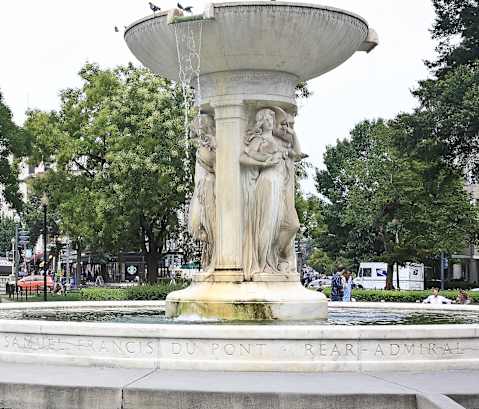 a water fountain in the middle of a park