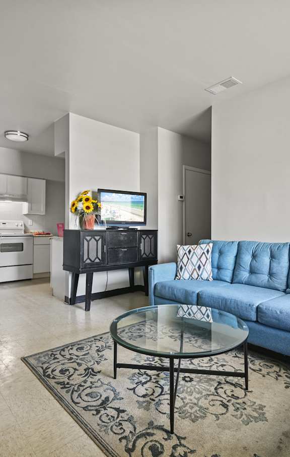 A spacious room with a ceiling fan and wooden flooring.