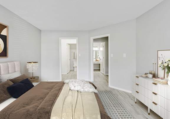 A bedroom with a large bed and a white dresser.