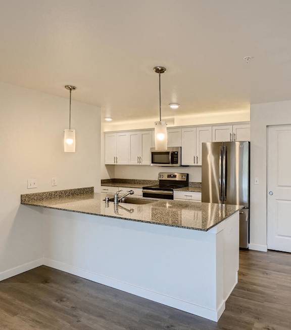 A kitchen with a white island and a refrigerator.