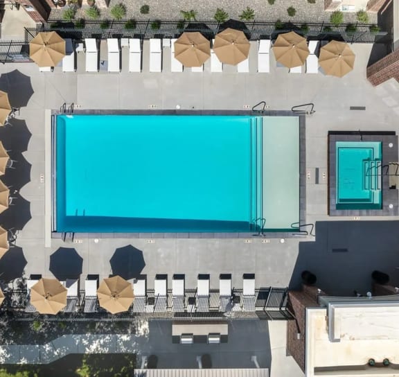 a pool area with umbrellas and chairs and a blue pool