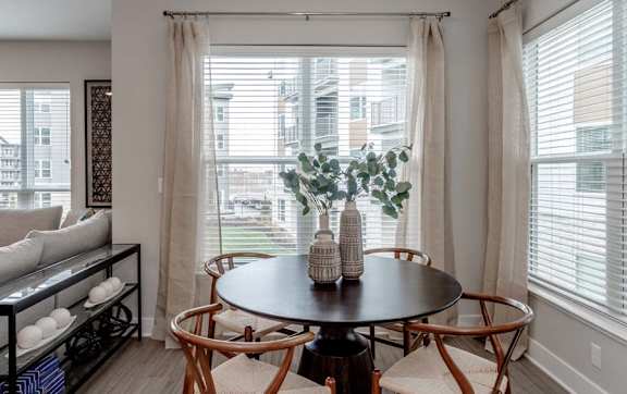 A dining room with a round table and chairs.
