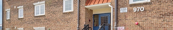a brick apartment building with a porch and stairs