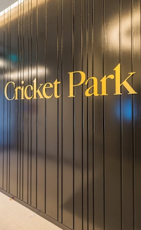 A wall with the words Cricket Park written on it.