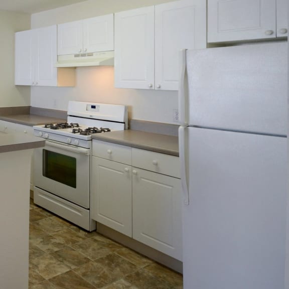 a kitchen with white cabinets and white appliances at Oak Glen Apartments, Orlando, 32808