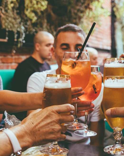 A group of people toasting with different types of alcoholic beverages.