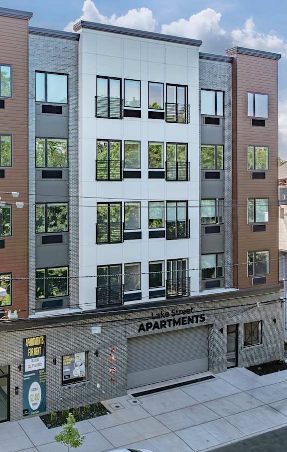 A modern apartment building with a sign that reads "Apartments".