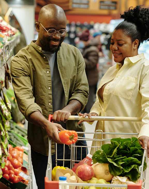 A man and woman shopping for groceries in a supermarket.