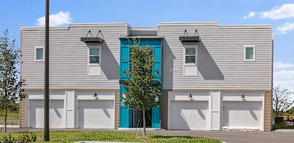 A modern two-story building with a blue door and windows.