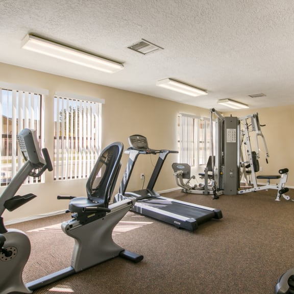 an exercise room with treadmills and other fitness equipment