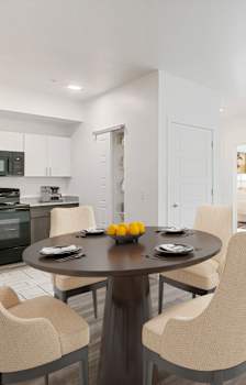 a dining room with a table and chairs and two windows