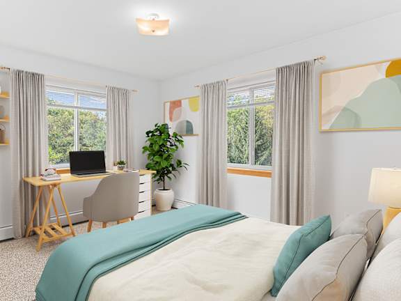 a bedroom with a bed and a desk with a computer