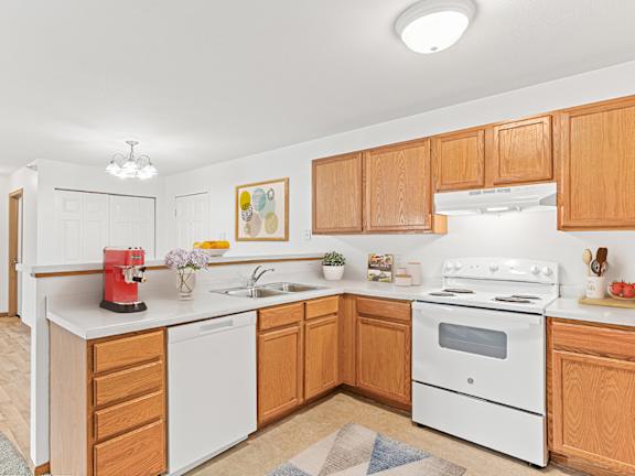 a kitchen with white appliances and wooden cabinets