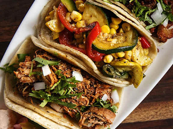A plate of tacos with corn and vegetables.