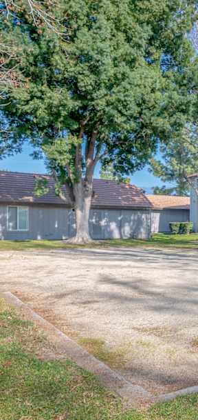 Apartment complex with a large grassy area in front.