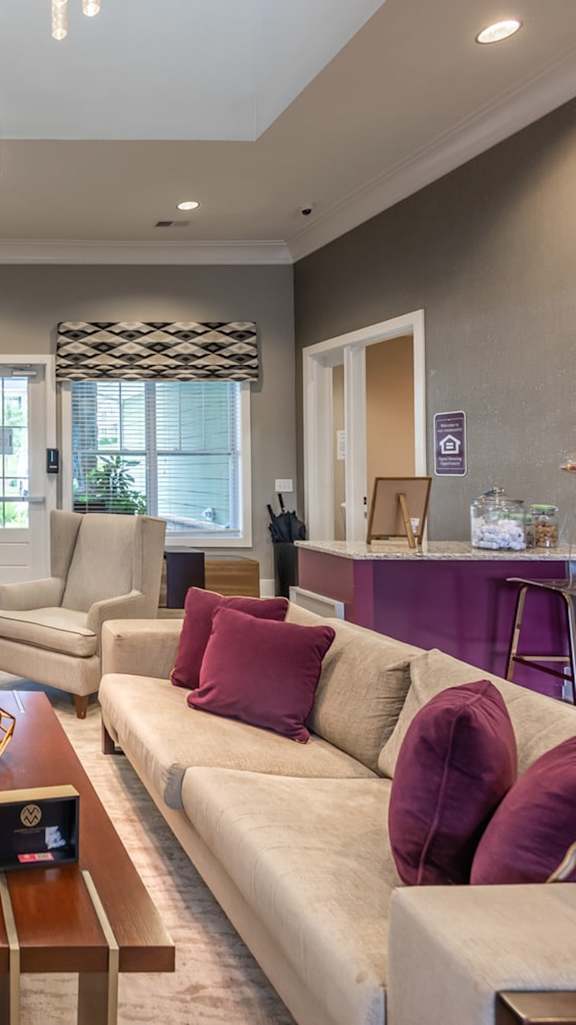 A modern living room with a grey sofa, a coffee table, and a painting on the wall. at Foxwood Apartments, Raleigh-Durham, NC, 27616